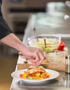 Chef à domicile sur Bruxelles qui met de la nourriture dans une assiette